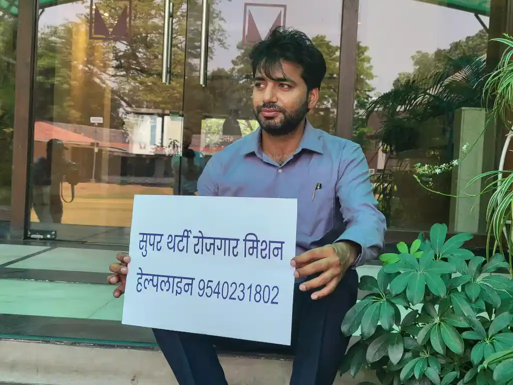Educationist Ankit Malhotra with helpline number placard.