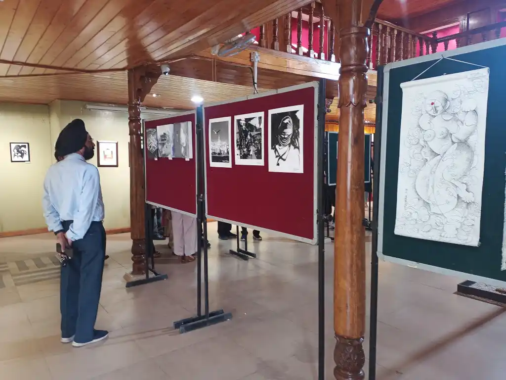 A person exploring paintings in an exhibition held at the Kangra Art Museum.